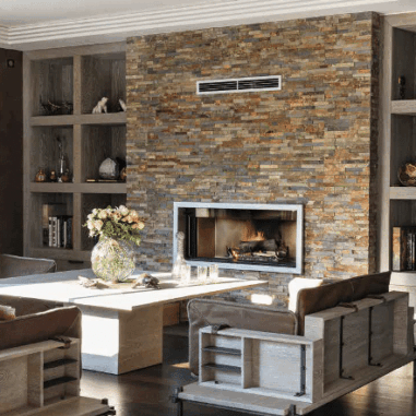 Encadré par deux grandes niches bibliothèque en chêne cérusé, le mur de la cheminée est ici habillé de barrettes d’ardoise oxydée de 10 cm d’épaisseur.