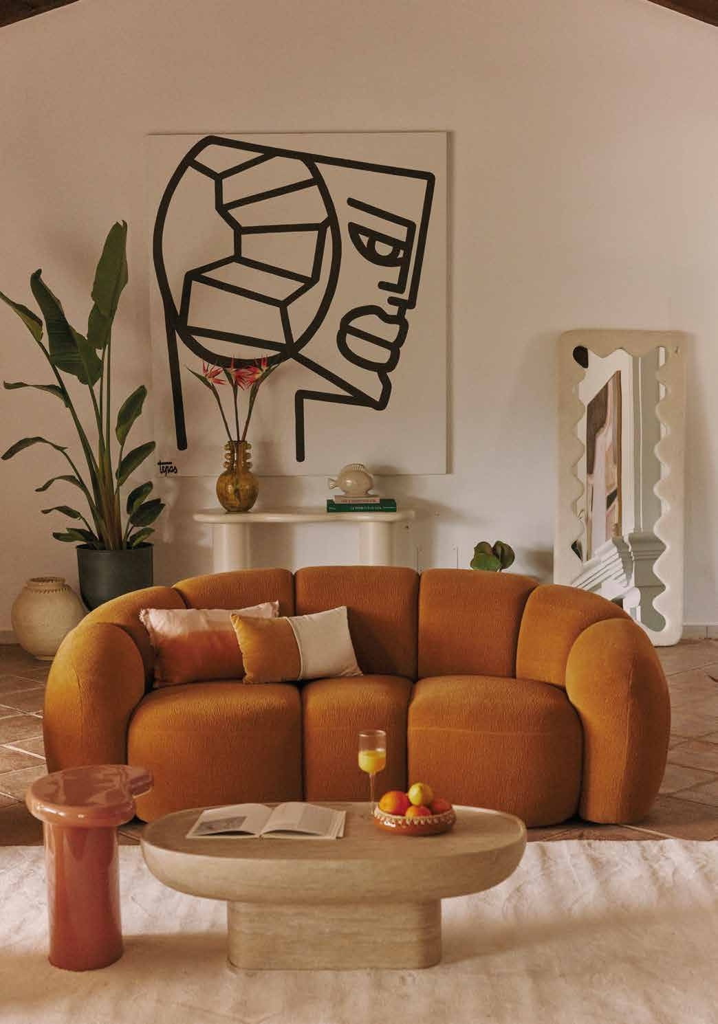 canapé arrondi couleur terracotta dans un salon design avec décoration artistique et ambiance chaleureuse