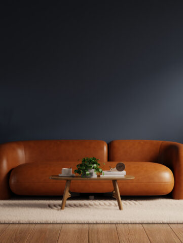 Salon tendance déco 2026 avec mur bleu nuit et canapé camel dans une ambiance chaleureuse