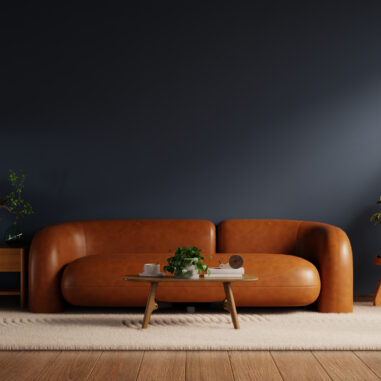 Salon tendance déco 2026 avec mur bleu nuit et canapé camel dans une ambiance chaleureuse