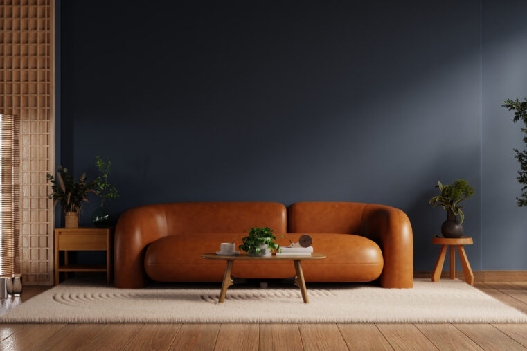 Salon tendance déco 2026 avec mur bleu nuit et canapé camel dans une ambiance chaleureuse