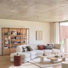 salon lumineux avec canapé blanc et bibliothèque en bois