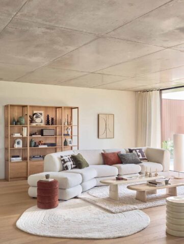 salon lumineux avec canapé blanc et bibliothèque en bois