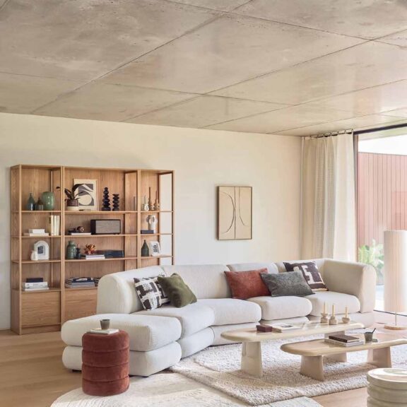 salon lumineux avec canapé blanc et bibliothèque en bois