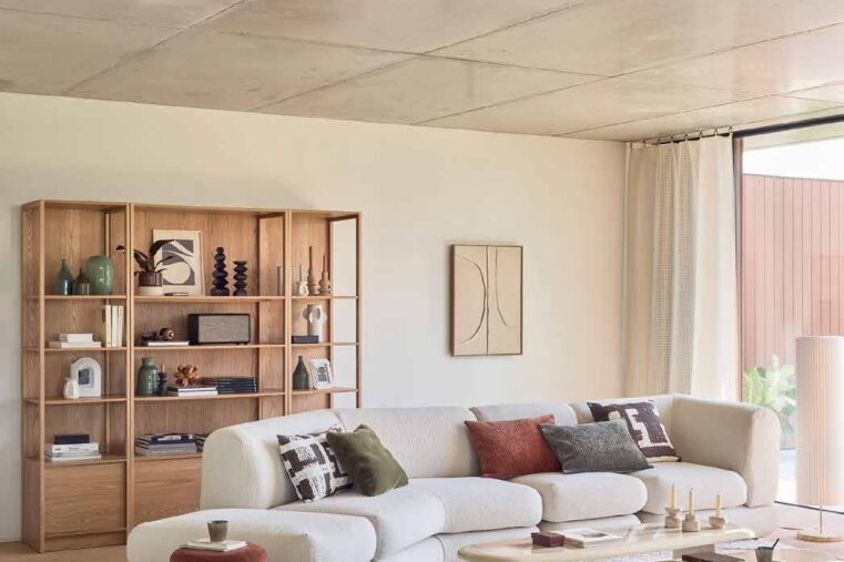 salon lumineux avec canapé blanc et bibliothèque en bois