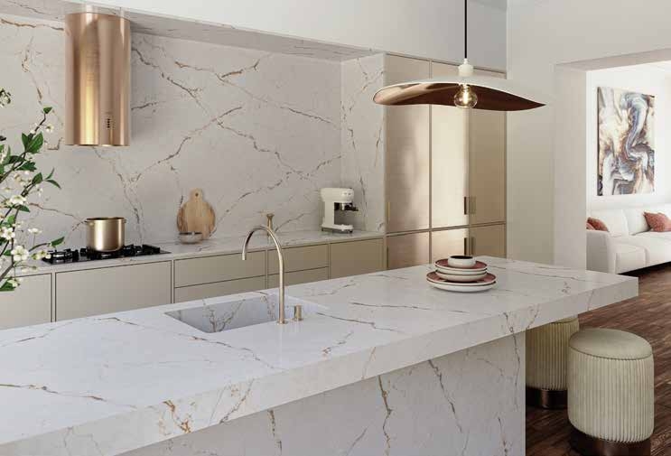 cuisine lumineuse avec îlot en marbre blanc et robinetterie dorée