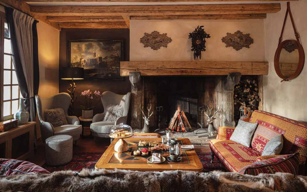 Salon de chalet de montagne avec cheminée en pierre, mobilier cosy et décoration chaleureuse en bois