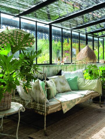 véranda aménagée avec banquette et plantes d’intérieur dans une ambiance jardin lumineux