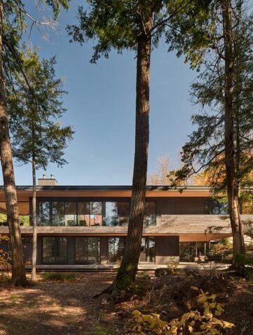 Maison en bois contemporaine en pleine nature avec façade minimaliste et intégration dans un environnement forestier