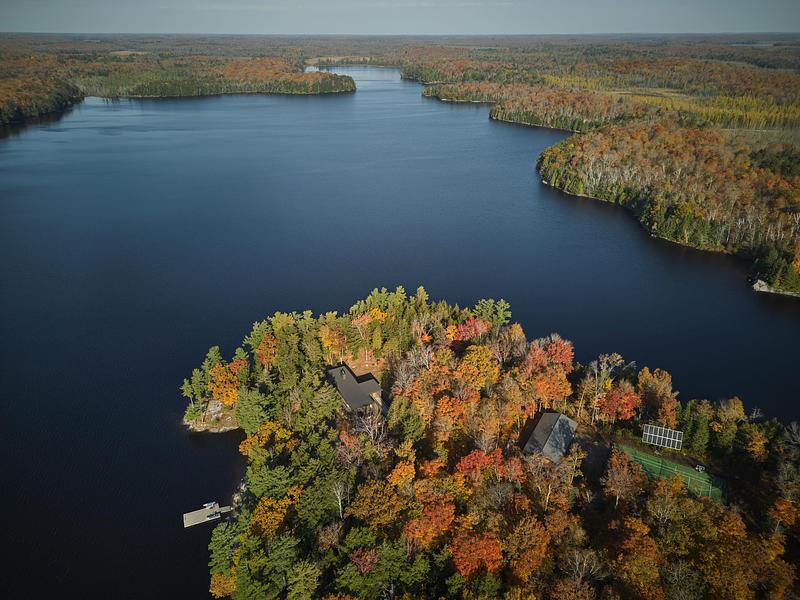 Vue aérienne d’une péninsule boisée au Canada avec maison en pleine nature entourée d’un lac