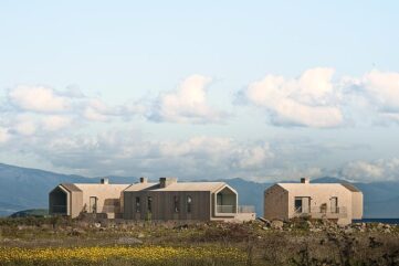 Complexe hôtelier contemporain en Turquie avec bâtiments en pierre et bois au cœur d’un paysage naturel sur la côte égéenne