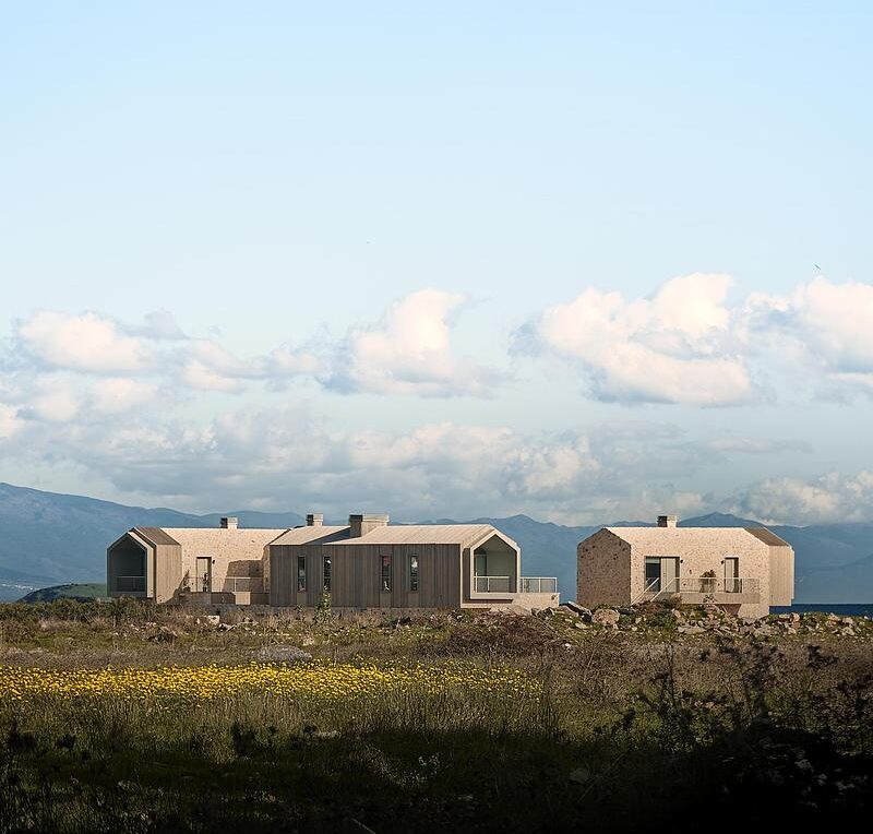 Complexe hôtelier contemporain en Turquie avec bâtiments en pierre et bois au cœur d’un paysage naturel sur la côte égéenne