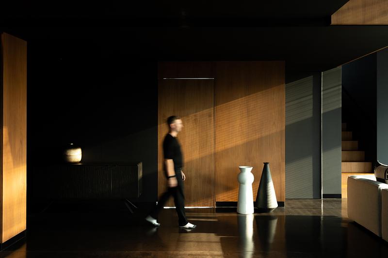 Intérieur minimaliste avec panneaux en bois et lumière naturelle créant une ambiance chaleureuse dans un espace contemporain