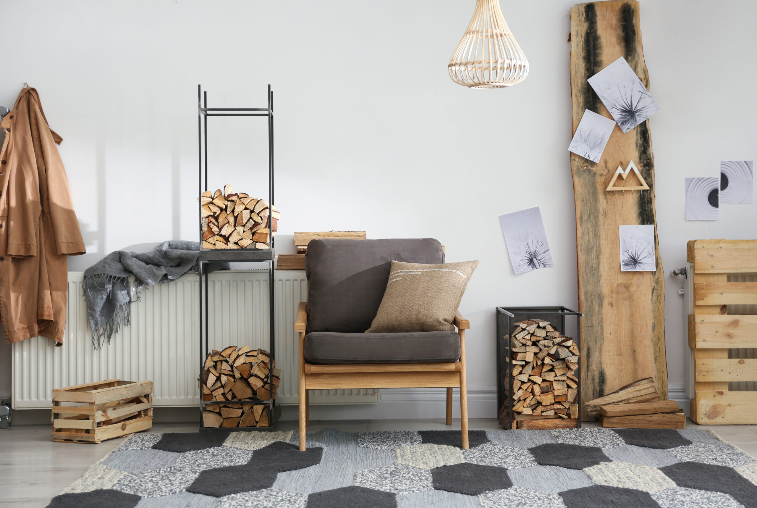 Coin salon cosy avec fauteuil, bois de chauffage et décoration naturelle dans un intérieur chaleureux