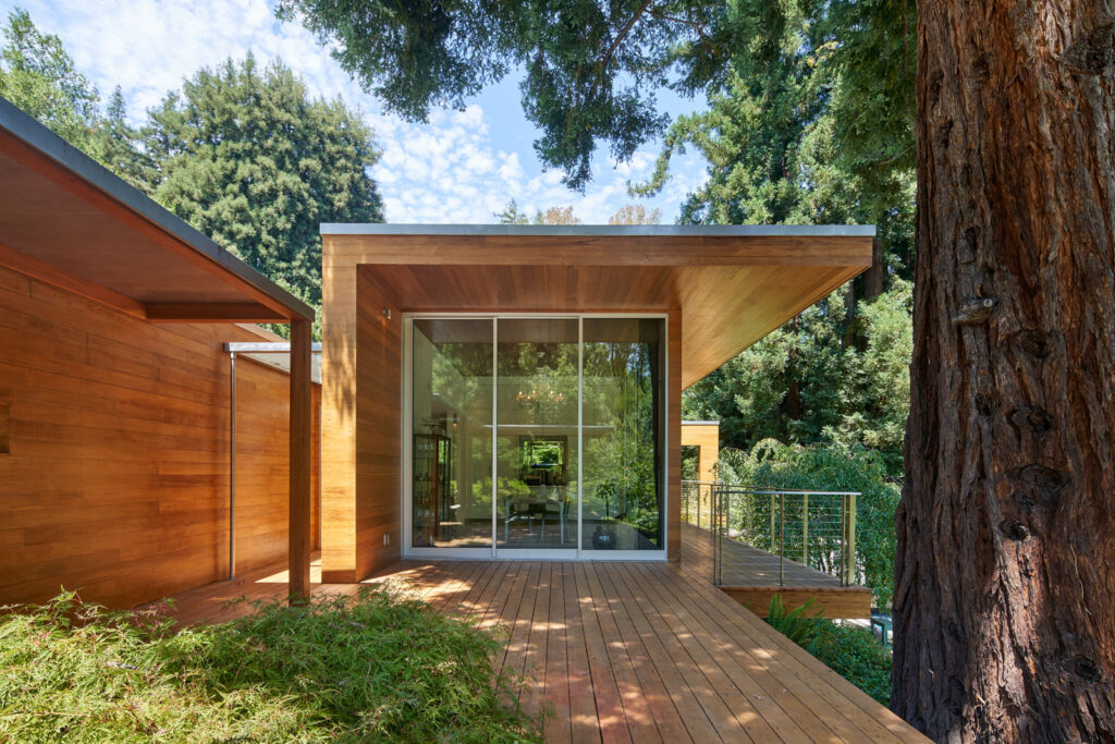 Maison moderniste avec terrasse en bois au milieu d’une forêt de redwoods