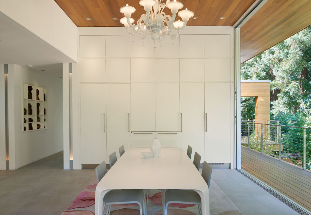 Salle à manger contemporaine ouverte sur les redwoods avec mobilier minimaliste et finitions en bois