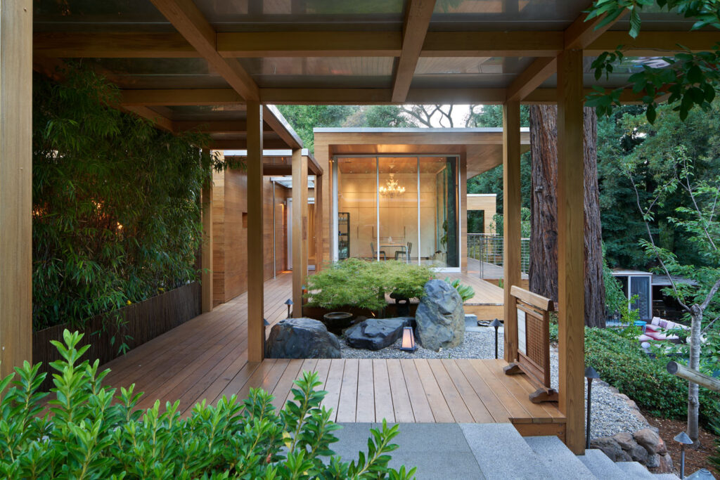 Terrasse contemporaine avec larges baies vitrées ouvertes sur la nature