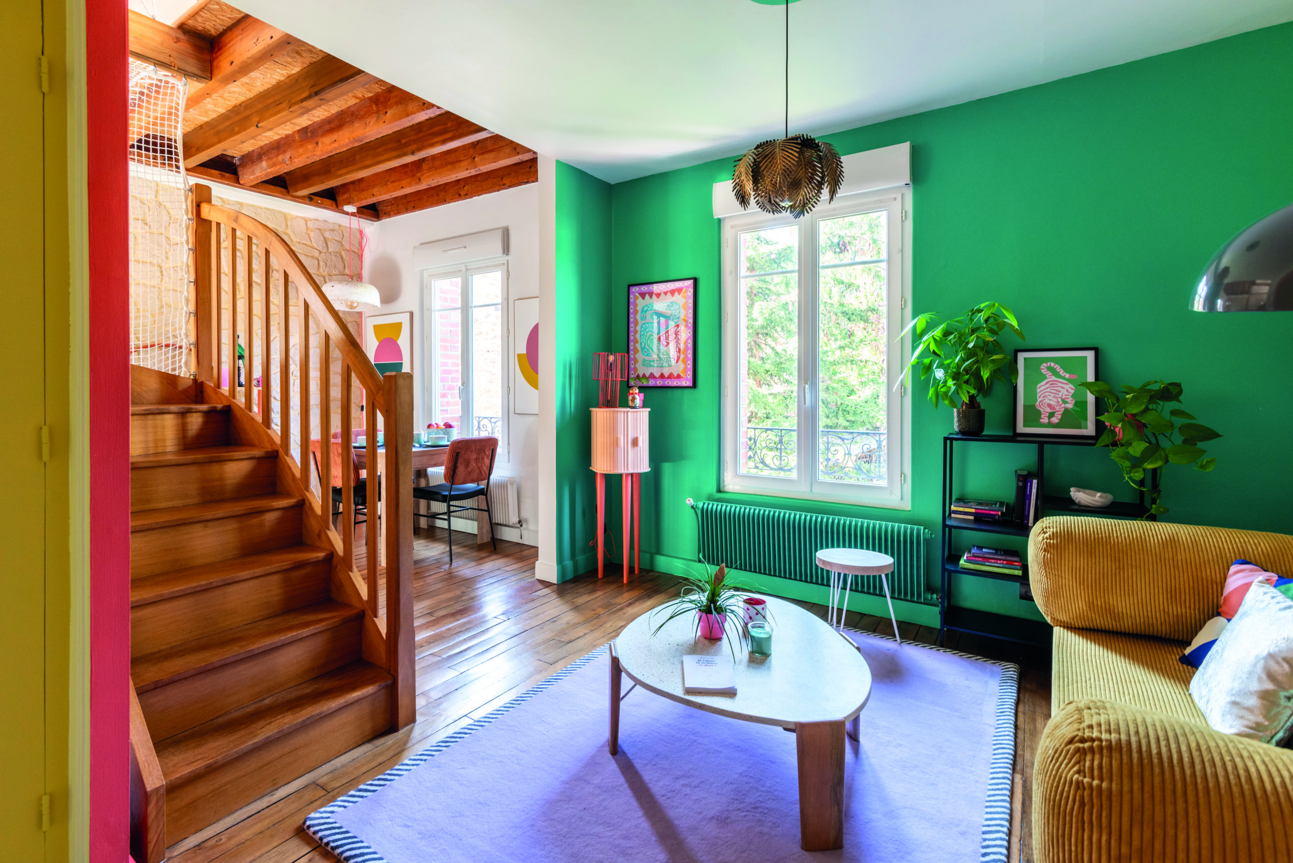 Salon moderne avec mur vert intense et décoration chaleureuse