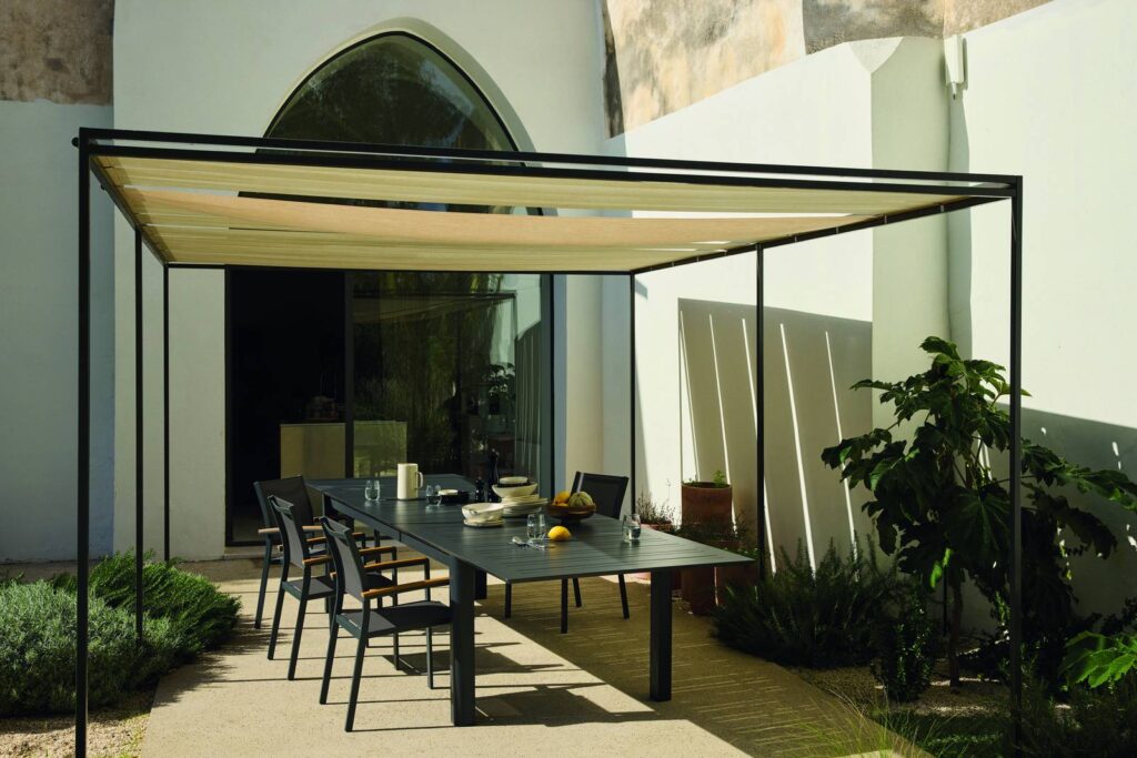 Pergola avec table de jardin sous une voile ombragée