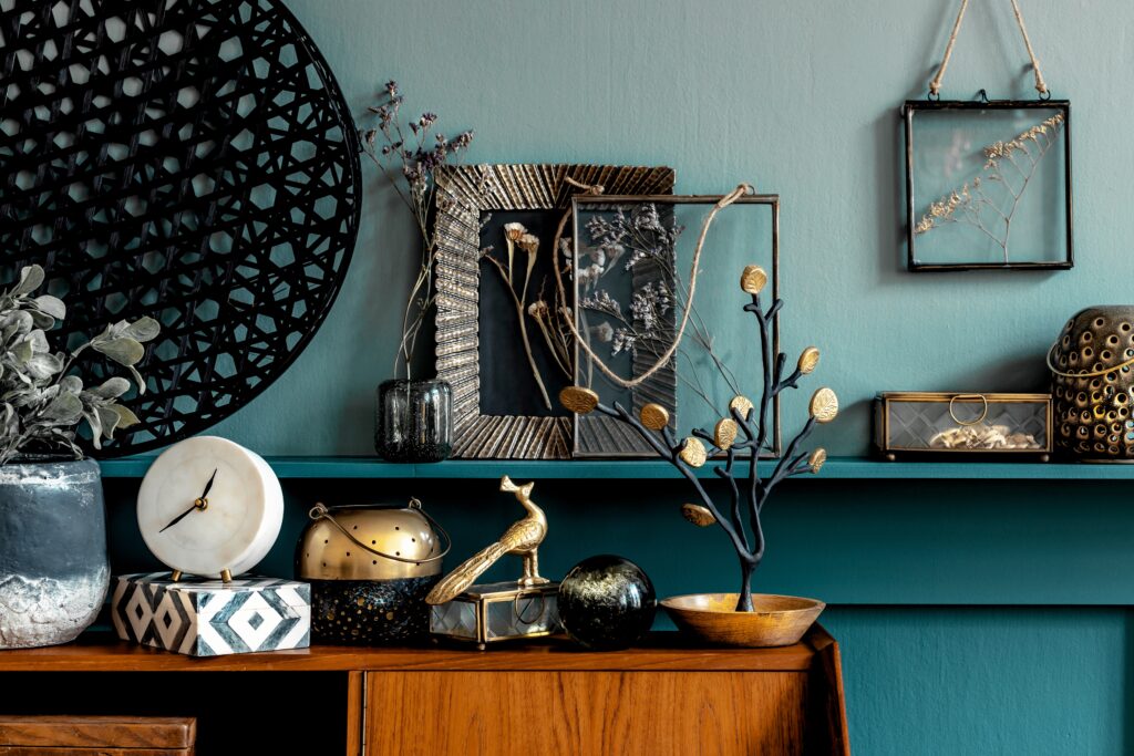 Décoration vintage avec objets chinés, cadres anciens et accessoires en laiton sur un buffet en bois