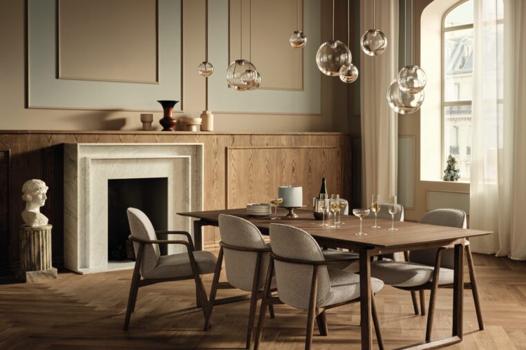 Salle à manger avec table en bois foncé configurable, chaises tapissées, cheminée en marbre et suspensions en verre