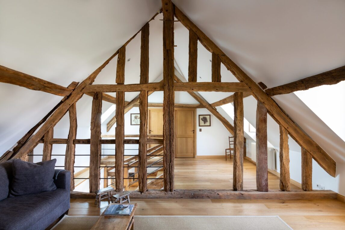 Grenier amenage en espace de vie avec charpente ancienne en bois et parquet chene
