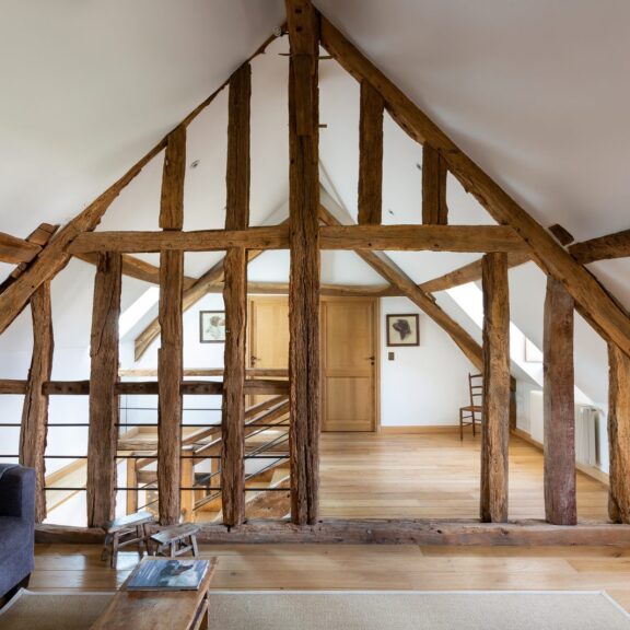 Grenier amenage en espace de vie avec charpente ancienne en bois et parquet chene