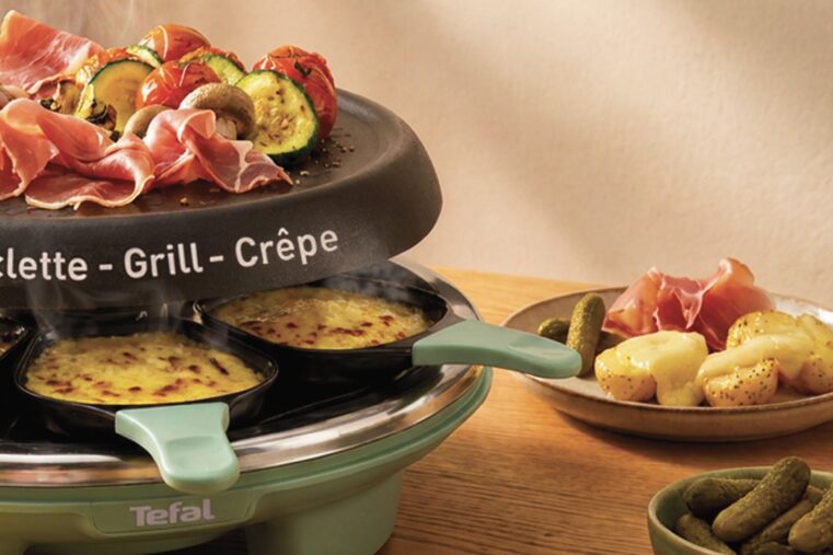 Appareil à raclette Tefal Raclette Célébration vert sauge, poêlons de fromage fondu sous une plaque garnie de jambon cru et de légumes grillés
