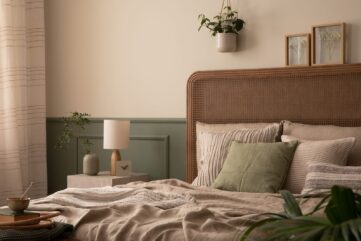 Aménager sa chambre pour mieux dormir : tête de lit en rotin, linge de lit en lin beige, coussin vert sauge et boiseries vert sauge